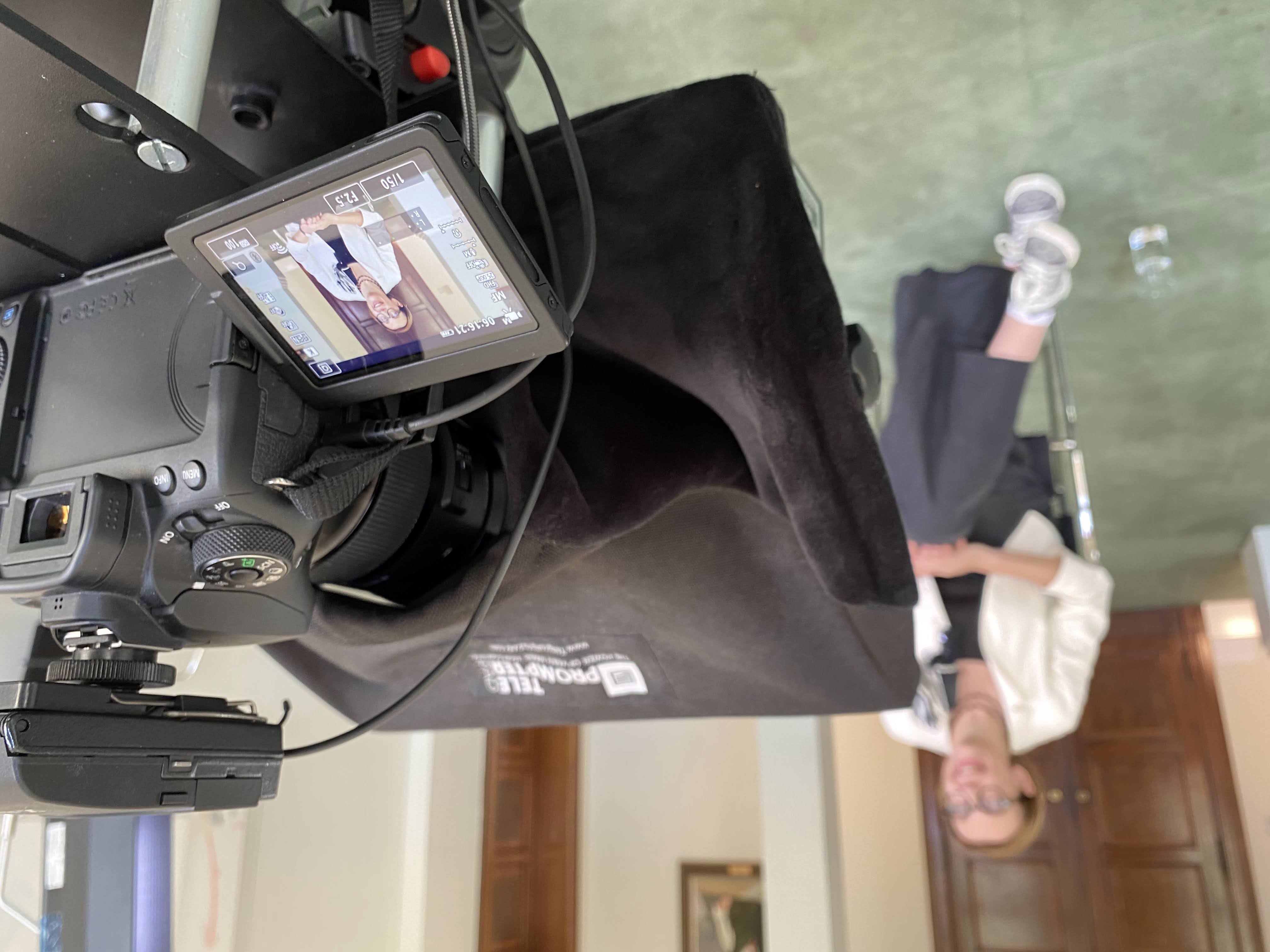 Anna Kwiatkowska, Deputy Director for Data Science at HM Revenue and Customs being filmed in a stately room. Camera, teleprompter and microphone in focus with the background slightly blurred.